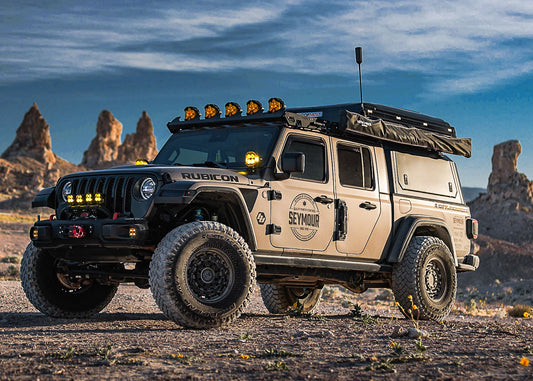 off road jeep rubicon with roof rack and lights in desert terrain