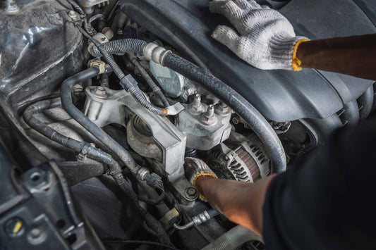 mechanic working on a car engine near the alternator